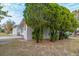 Side view of a tan house with lush green landscaping at 5815 Harrington Dr, Orlando, FL 32808