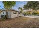 Tan house with sliding glass doors, multiple windows, and a large backyard at 5815 Harrington Dr, Orlando, FL 32808