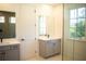 Double vanity bathroom with gray cabinets and a large mirror at 7493 Estuary Lake Loop, Kissimmee, FL 34747