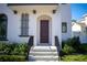 Dark brown front door with black railings and landscaping at 7493 Estuary Lake Loop, Kissimmee, FL 34747