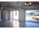 Two-car garage with open doors, epoxy flooring and view of the street at 7493 Estuary Lake Loop, Kissimmee, FL 34747