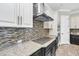 Contemporary kitchen with mosaic tile backsplash, stainless steel range hood, and smooth cooktop at 7878 Greengard St, Orlando, FL 32827