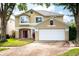 Two-story house with a tan exterior, a two-car garage, and landscaping at 11520 Robbyes Dr, Orlando, FL 32817