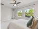 Bedroom with ceiling fan, two windows, and view of backyard at 17860 Passionflower Cir, Clermont, FL 34714