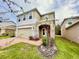 Two-story house with a beige exterior, brick driveway and landscaping at 1839 Osprey Perch Rd, Davenport, FL 33837