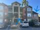 Condo building exterior with parking lot and landscaping at 2208 Antigua Pl # 924, Kissimmee, FL 34741
