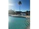 Community pool with palm trees and lake view at 2208 Antigua Pl # 924, Kissimmee, FL 34741