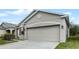 Tan one-story house with two-car garage and landscaped yard at 2267 Canyon Breeze Ave, Kissimmee, FL 34746