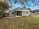 Private backyard with covered patio and spacious grassy area at 3218 Ginger Cir, Orlando, FL 32826