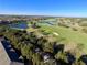 Aerial view of community, featuring golf course and lake at 7128 Five Oaks Dr, Harmony, FL 34773