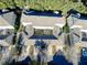 Aerial view of townhouses, showing building rooftops and surrounding trees at 7128 Five Oaks Dr, Harmony, FL 34773