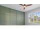 Bedroom with wood ceiling fan, green accent wall, and window with shutters at 927 Pecan St, Oviedo, FL 32765