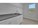 Laundry room with white cabinets, gray countertop, and window at 113 Douglas St, Edgewater, FL 32141