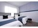 Two twin beds with blue bedding and gray headboard in a well-lit bedroom at 212 Villa Domani Cir, Davenport, FL 33896