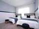 Two twin beds with blue bedding and gray headboard in a well-lit bedroom at 212 Villa Domani Cir, Davenport, FL 33896