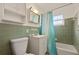 Clean bathroom with green tile and a blue shower curtain at 640 N Orange Ave, Orange City, FL 32763