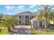 Two-story house, gray exterior, paver driveway, palm trees, and green lawn at 9168 Lake Avon Dr, Orlando, FL 32829