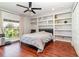 Bedroom with hardwood floors, built-in shelves, and large window at 9168 Lake Avon Dr, Orlando, FL 32829