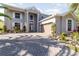 Two-story house with gray exterior, paver driveway, and palm trees at 9168 Lake Avon Dr, Orlando, FL 32829