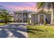 Two-story house with gray exterior, paver driveway, and lush landscaping at 9168 Lake Avon Dr, Orlando, FL 32829