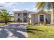 Two-story house with gray exterior, paver driveway, and lush landscaping at 9168 Lake Avon Dr, Orlando, FL 32829