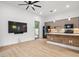 Open living room with kitchen access and large TV at 10230 Park Ridge Gotha Rd, Windermere, FL 34786