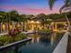 Luxury pool and patio at sunset, surrounded by landscaping at 10230 Park Ridge Gotha Rd, Windermere, FL 34786