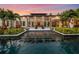 Expansive pool and patio area with fire pits at sunset at 10230 Park Ridge Gotha Rd, Windermere, FL 34786