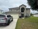 Two-story house with a large yard and a two-car garage at 1403 Kissimmee Ct, Kissimmee, FL 34759