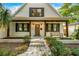 White brick home with a wood front porch and a charming bench at 2330 Westminster Ct, Winter Park, FL 32789
