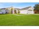 House with a large front yard, two-car garage, and green grass at 246 Anson Dr, Kissimmee, FL 34758