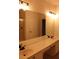 Double vanity with lighted mirror and beige countertop at 2525 San Tecla St # 101, Orlando, FL 32835