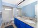 Bathroom with blue vanity, granite countertops, and dual sinks at 3279 Fairfield Dr, Kissimmee, FL 34743