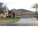 Tan two-story house with a three car garage and manicured lawn at 428 Palastro Ave, Auburndale, FL 33823