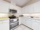 Modern kitchen with white cabinets, granite countertops, and stainless steel appliances at 110 Coleman St, Edgewater, FL 32141