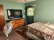 Spacious bedroom with a large TV, dresser, and carpet flooring at 1701 N Hastings St, Orlando, FL 32808