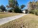 Ranch house with overgrown yard and driveway at 1701 N Hastings St, Orlando, FL 32808