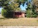 Brick house with a burgundy accent and overgrown yard at 1701 N Hastings St, Orlando, FL 32808