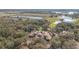 Aerial view of a large house and surrounding landscape with lakes and golf course at 25628 Hawks Run Ln, Sorrento, FL 32776