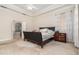 Spacious bedroom with a large bed, dark wood furniture, and a view of the bathroom at 25628 Hawks Run Ln, Sorrento, FL 32776