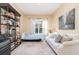 Cozy bedroom with built-in shelving, a sofa, and a window at 25628 Hawks Run Ln, Sorrento, FL 32776