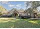 One-story home with stone accents, red door, and landscaped lawn at 25628 Hawks Run Ln, Sorrento, FL 32776
