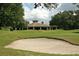 View of a clubhouse from the golf course, featuring a sand trap in the foreground at 25628 Hawks Run Ln, Sorrento, FL 32776