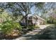 Single-story house with stone accents and a large tree in the front yard at 25628 Hawks Run Ln, Sorrento, FL 32776