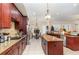 Large kitchen with dark wood cabinets, granite countertops, and an island at 25628 Hawks Run Ln, Sorrento, FL 32776