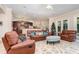 Cozy living room boasts leather furniture, a large area rug, and a view of the kitchen at 25628 Hawks Run Ln, Sorrento, FL 32776