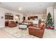 Spacious living room with leather furniture, a Christmas tree, and built-in shelving at 25628 Hawks Run Ln, Sorrento, FL 32776
