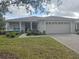Tan one-story house with a two-car garage and landscaped front yard at 501 Heritage Trail St, Kissimmee, FL 34759
