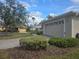 Attached garage with a neutral-colored door and landscaping at 501 Heritage Trail St, Kissimmee, FL 34759
