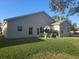 Back patio with seating and umbrella, adjacent to house at 501 Heritage Trail St, Kissimmee, FL 34759